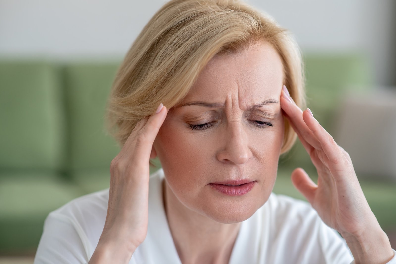 Midaged blone woman suffering from a headache